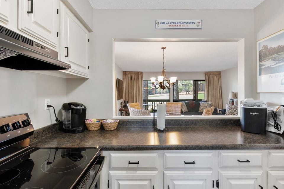 Open kitchen layout with a serving bar overlooking the dining and living room.
