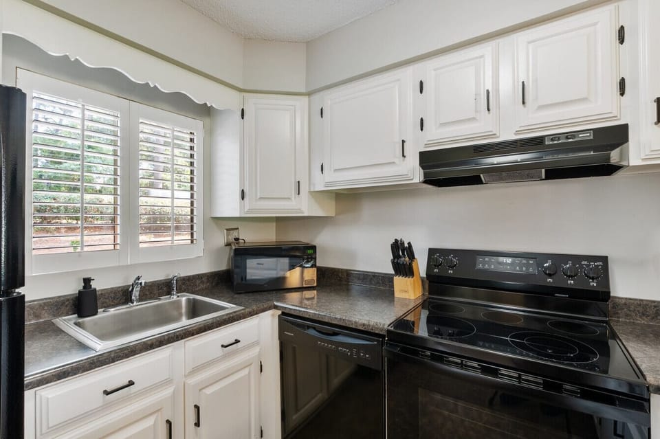 Bright kitchen corner featuring a large window and everything you need to cook.