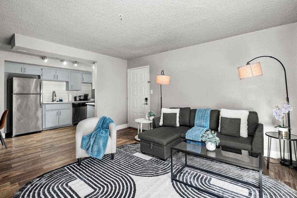 Modern living room, dedicated working space, TV, plush couch, and sofa bed