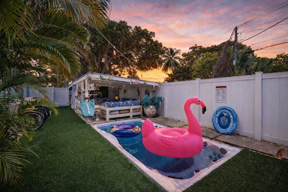 Private tropical backyard with a swim spa and shaded cabana—perfect for sunny days and laid-back evenings.