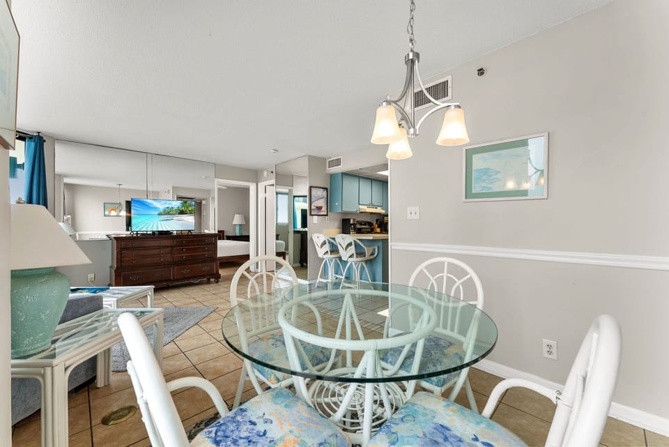 Dining area with glass table and open view to the kitchen and living room