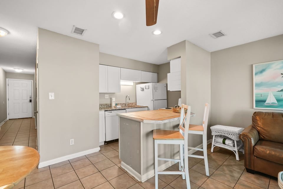 open kitchen with a breakfast bar and seating in a neutral-toned living space