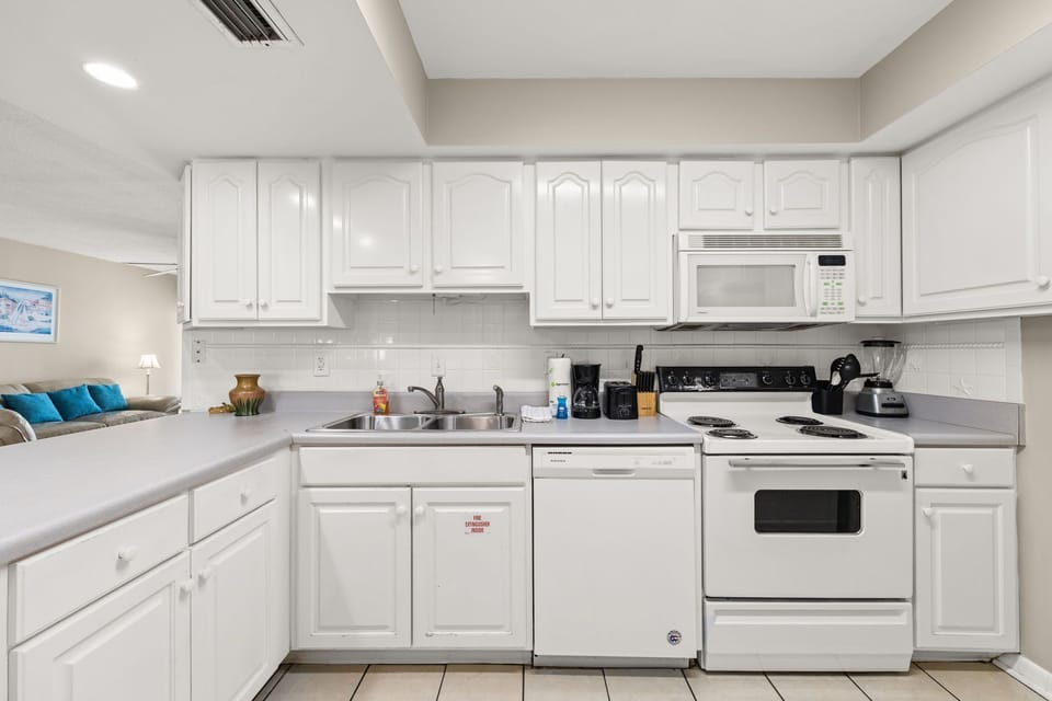 clean white kitchen with modern appliances and ample counter space