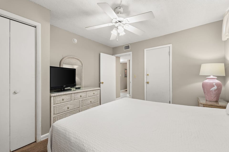 Cozy bedroom with neutral tones and a ceiling fan for comfort