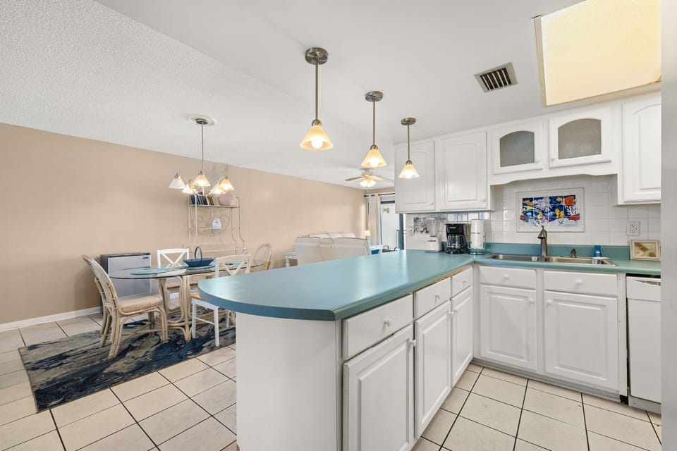 Open kitchen with a teal countertop and adjacent dining area for family meals.