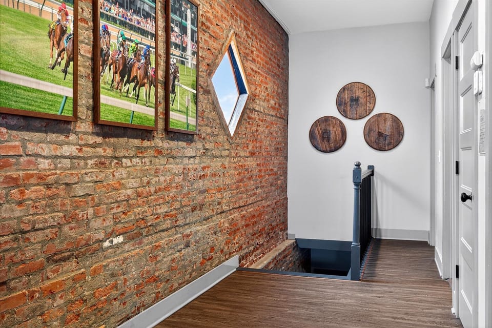 Head up the stairs past the gallery wall featuring framed horse racing jockey silks. The exposed brick follows you all the way up to the second level.