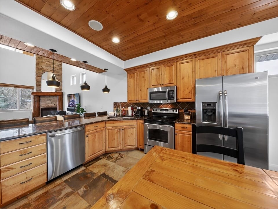 Your spacious kitchen features warm wood cabinetry, granite countertops, and stainless steel appliances for effortless meal preparation.
