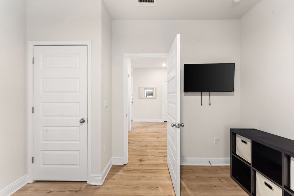 Your bright, modern space features warm wood floors, clean white walls, and a wall-mounted TV for cozy entertainment nights.