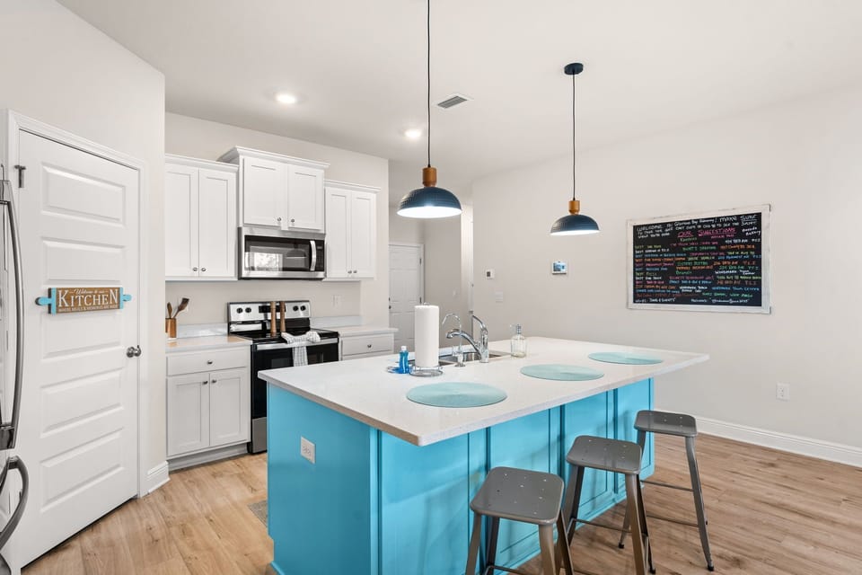 Your bright, fully-equipped kitchen features modern appliances and a cheerful turquoise island perfect for cooking meals together.