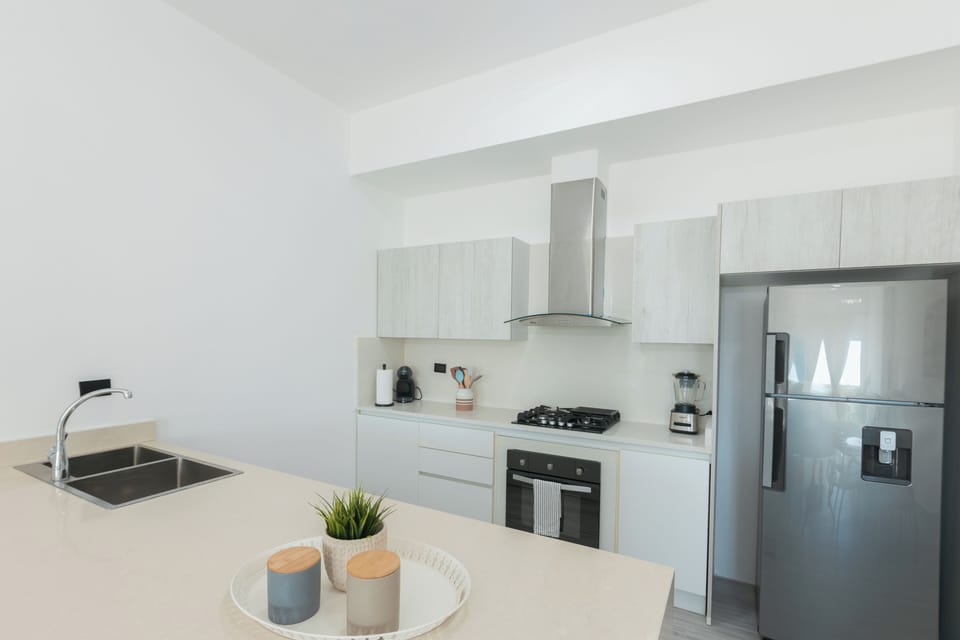 full kitchen with gas range and oven. stocked with cooking utensils and dishware