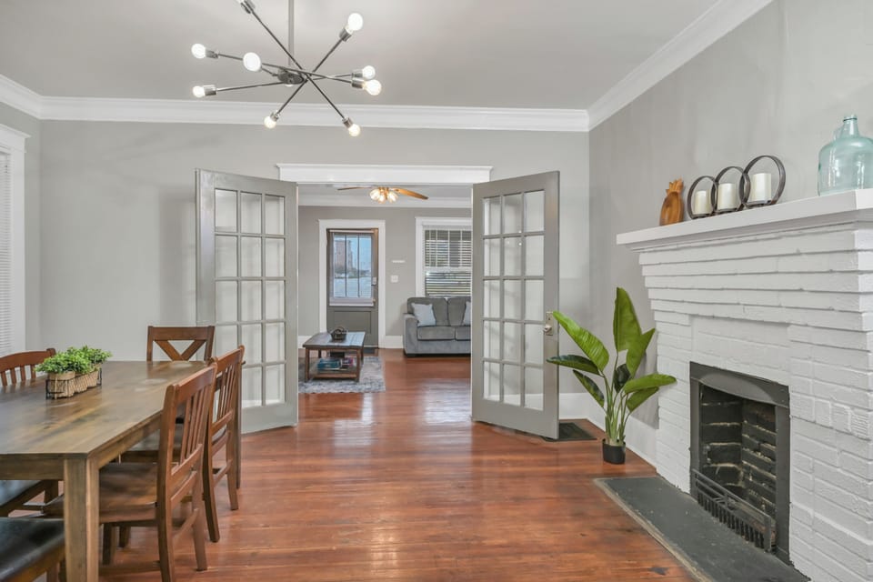 Bright dining room with fireplace, hardwood floors, and French doors