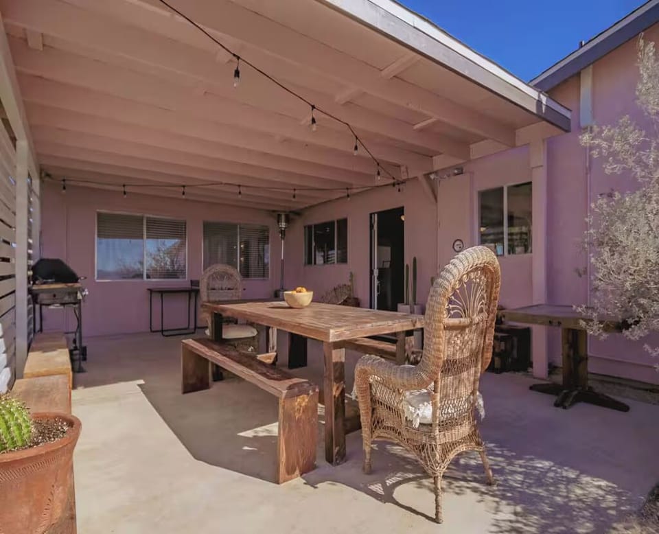 Whether it's a home cooked meal or BBQ the long wood dining table at the front of the house is the perfect place to enjoy dinner. Complete with cactus, vintage rattan chairs and strings of lights is pretty magical. 