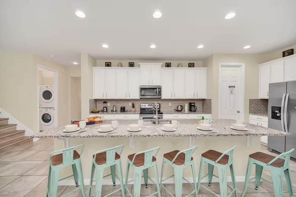 Kitchen with island & stacked washer/dryer — Sawyer Palm Kissimmee