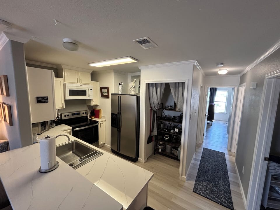 Kitchen with supply closet and cooking ware.