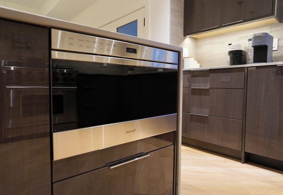 Premium Wolf wall microwave integrated into custom cabinetry.