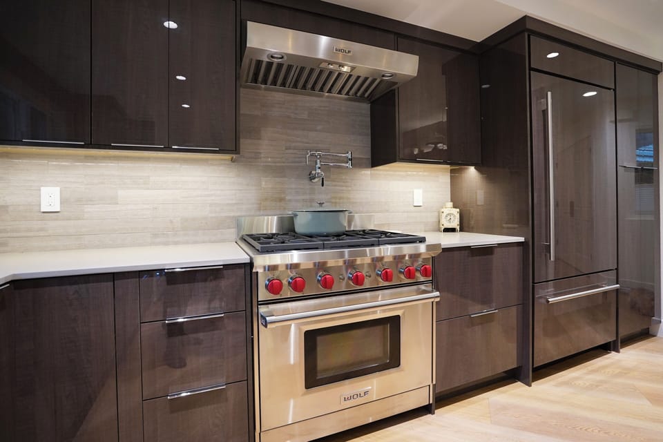 Wolf gas range with pot filler and Sub-Zero refrigerator—chef-level design.