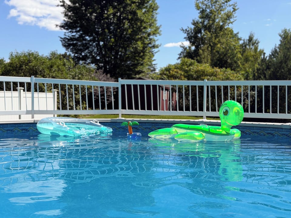 Sunny fenced pool with fun floats for relaxing summer days
