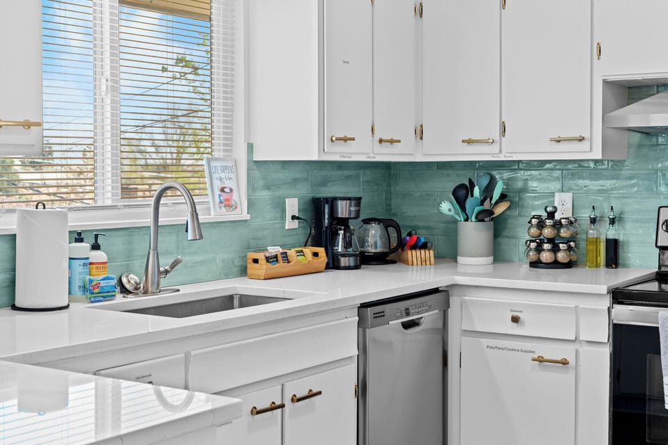 Kitchen stocked with seasonings, coffee, tea, utensils, cookware