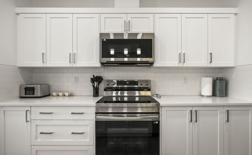 Well-appointed kitchen featuring stainless steel range and oven with hood