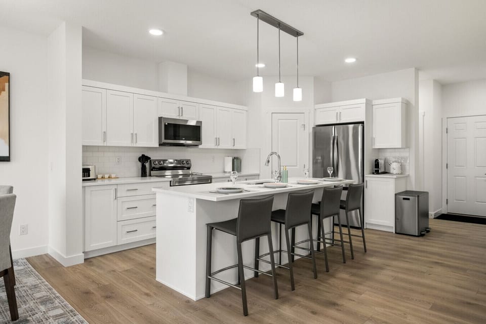 Modern kitchen with stainless steel appliances, white cabinetry, and breakfast island
