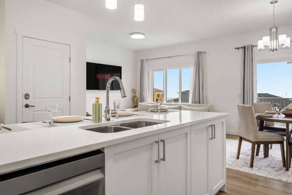 Well-equipped kitchen featuring white cabinetry, island seating, and stainless steel appliances