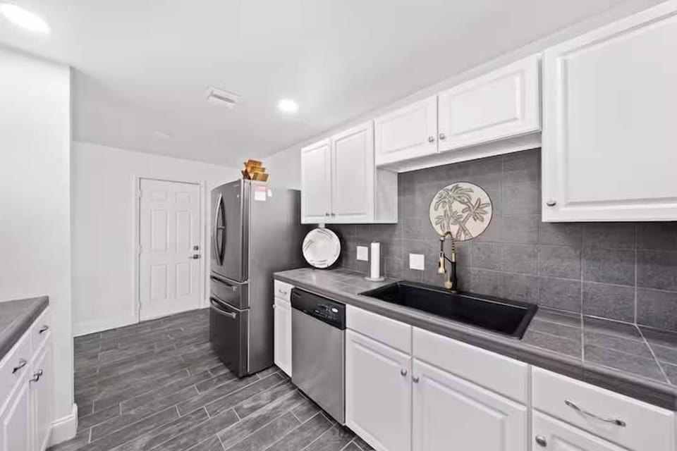 Modern kitchen with stainless steel appliances and gray tile flooring