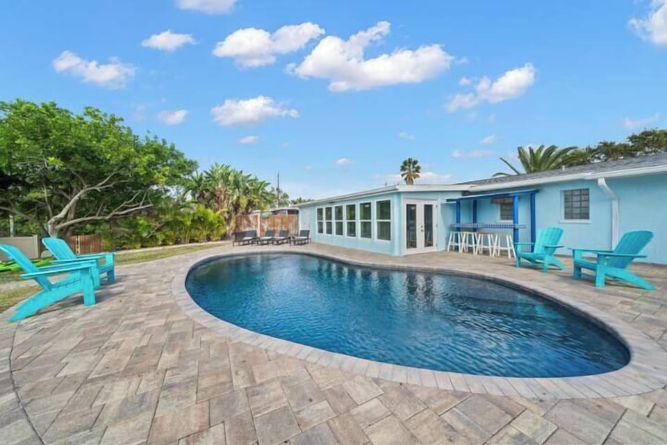 Relax by the kidney-shaped pool surrounded by a spacious patio and vibrant seating.