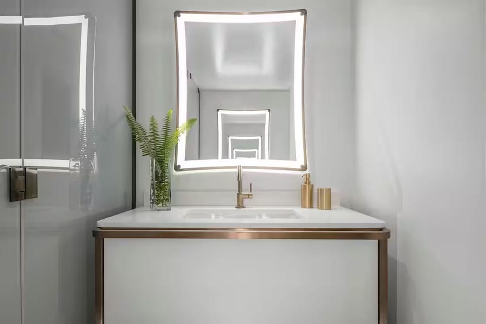 Refresh at a glowing mirror vanity with luxe brass accents.