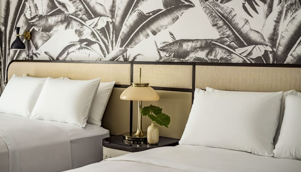 Drift off on cloud-soft pillows beside warm, ambient bedside lighting.