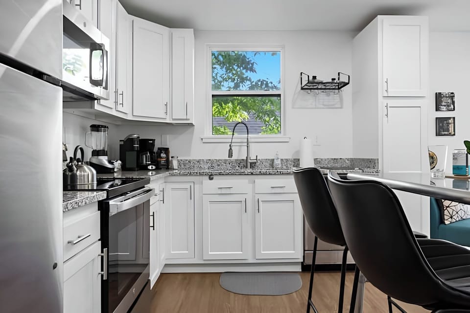 A sleek kitchen with white cabinets and stainless steel appliances.