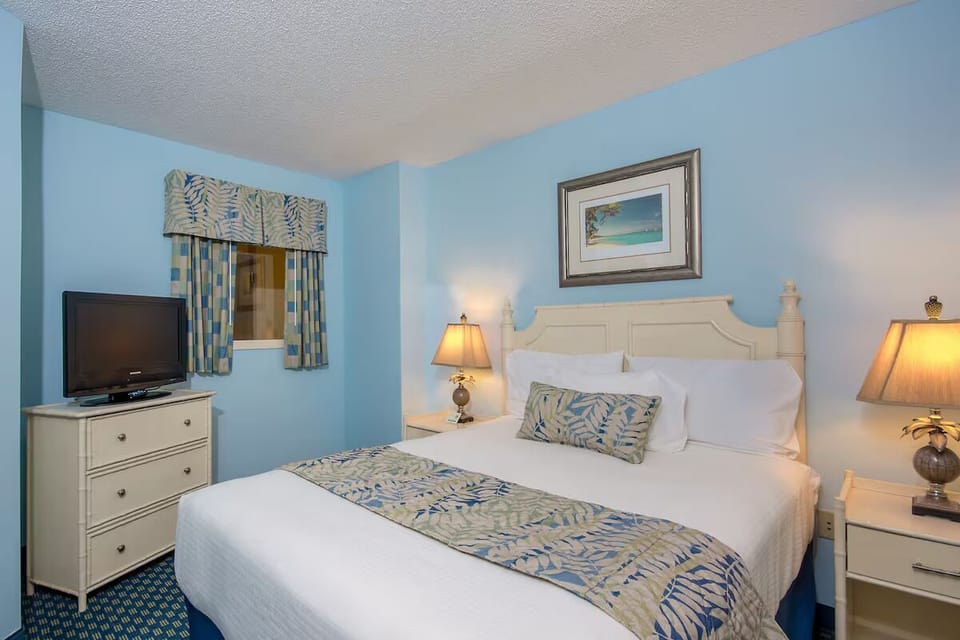 Unwind in a calm queen room with warm bedside lighting.