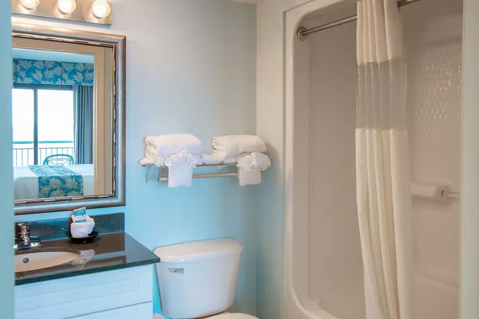 Refresh after the beach with bright vanity and shower-tub.