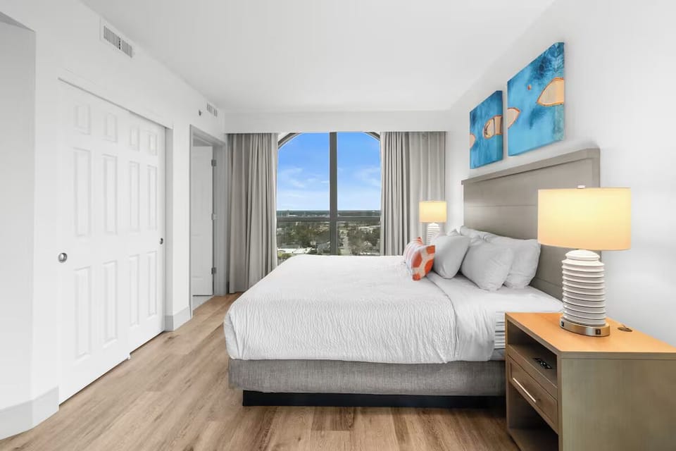Unwind in a sunlit bedroom with sweeping skyline views.
