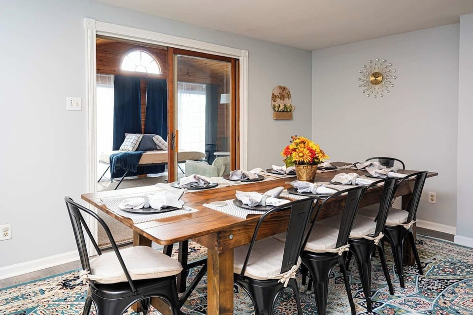 This angle highlights the grand dining table, perfect for large group meals, and the entryway into the wood-paneled sunroom