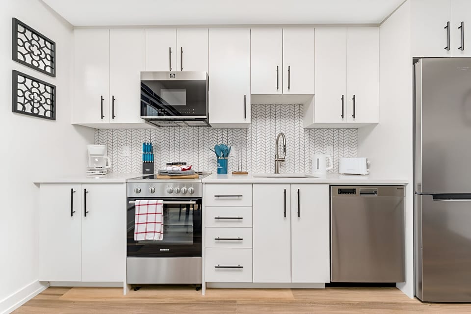Fully Equipped Kitchen With Stainless Steel Appliances And Quartz Countertops