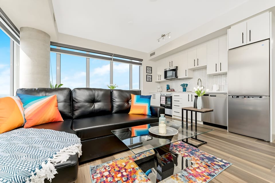 Open Living And Dining Space With Floor-To-Ceiling Windows And Ample Seating