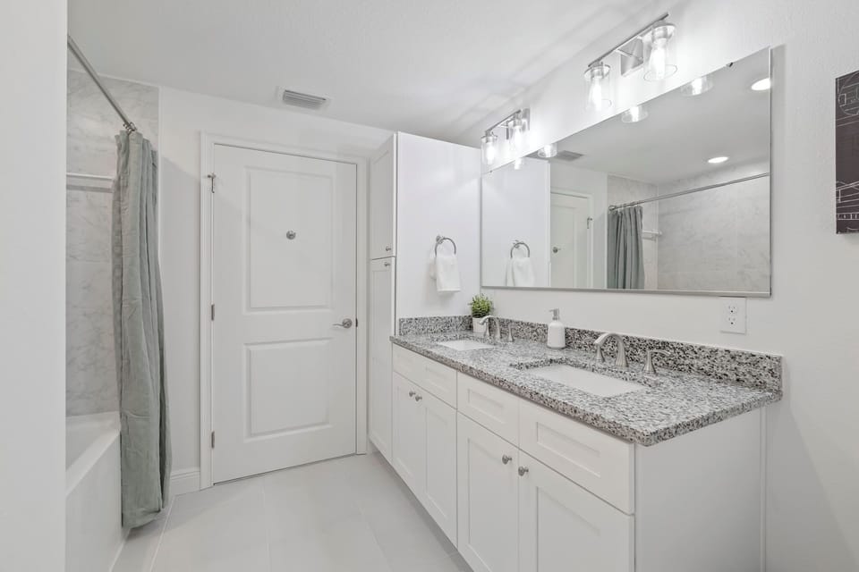 Modern bathroom with granite double vanity and bright lighting