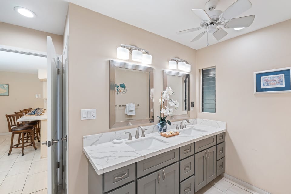 Elegant bathroom featuring a spacious vanity with double sinks, large mirror, and bright lighting for a fresh start.