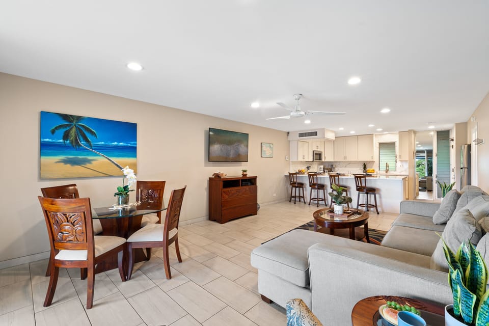 Comfortable living room featuring plush seating, vibrant island-themed art, and easy access to outdoor spaces.