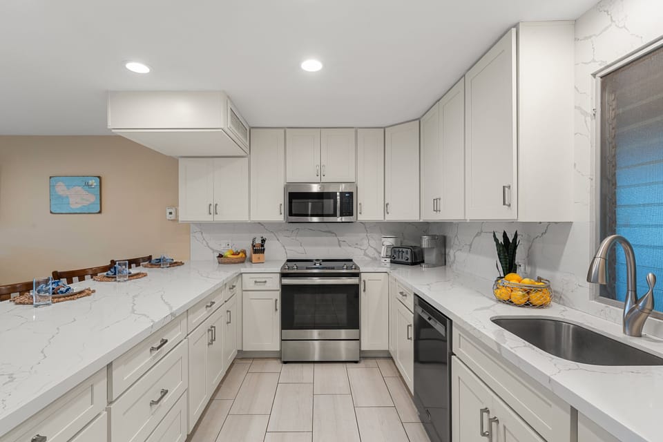 Sleek kitchen with white cabinetry, stainless steel appliances, and ample counter space for cooking and entertaining.