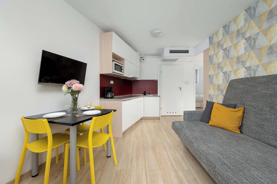 Open-plan with sofa bed, kitchenette, and dining area.