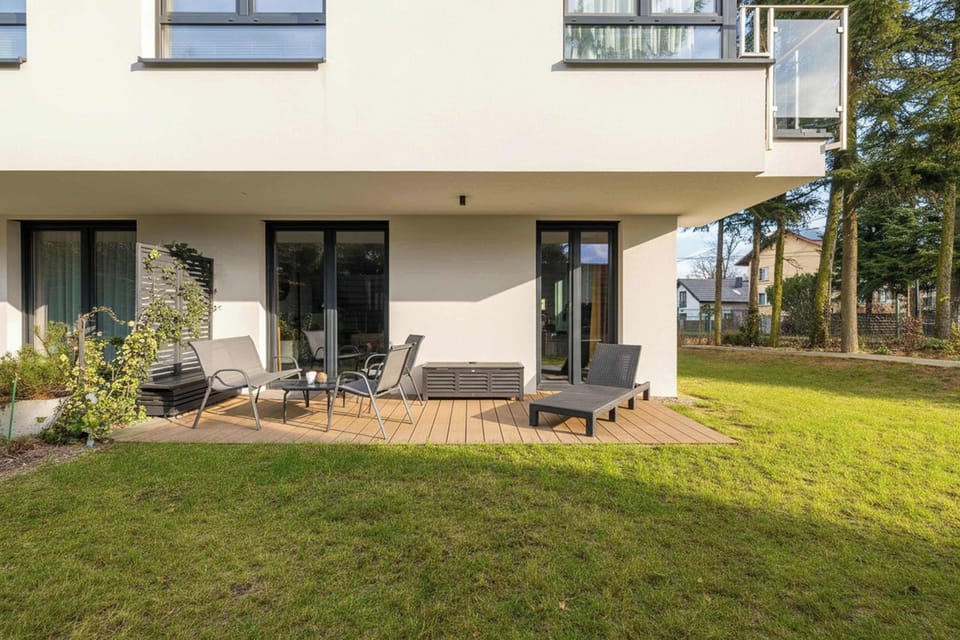 View of the building's facade and the apartment's terrace with a comfortable sun lounger.