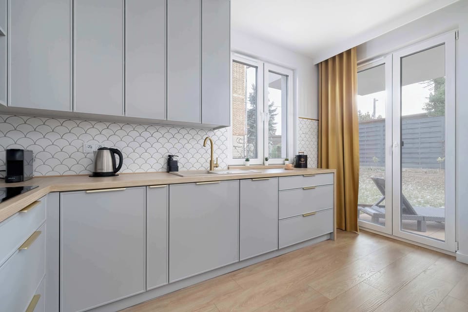 Kitchenette with modern cabinets, a kitchen island, and stainless steel appliances.
