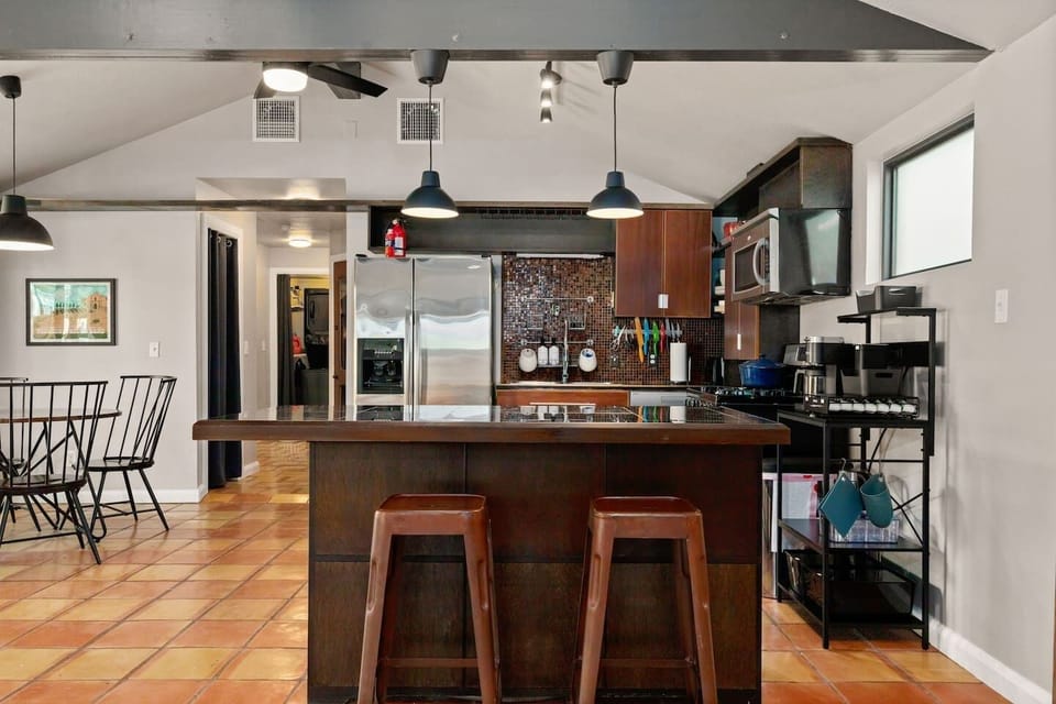 Modern kitchen with stainless appliances bar seating and all cookware included for home-style meals.