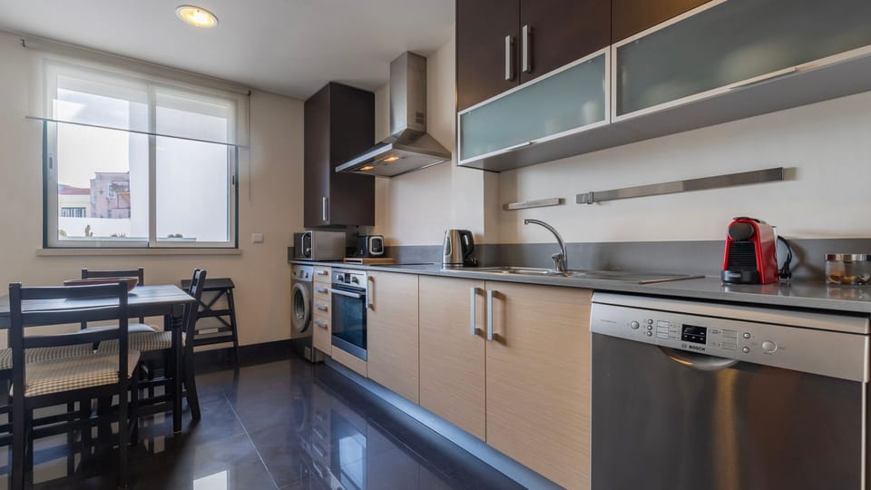 A modern and functional kitchen, equipped with high-quality appliances, including a washing machine, oven, and coffee machine. #appliances #apartment #vacations #lisbon