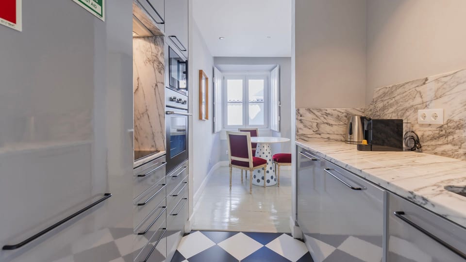 A gourmet kitchen with marble countertops and checkerboard flooring, blending classic and contemporary aesthetics. #CulinaryLuxury #TimelessDesign