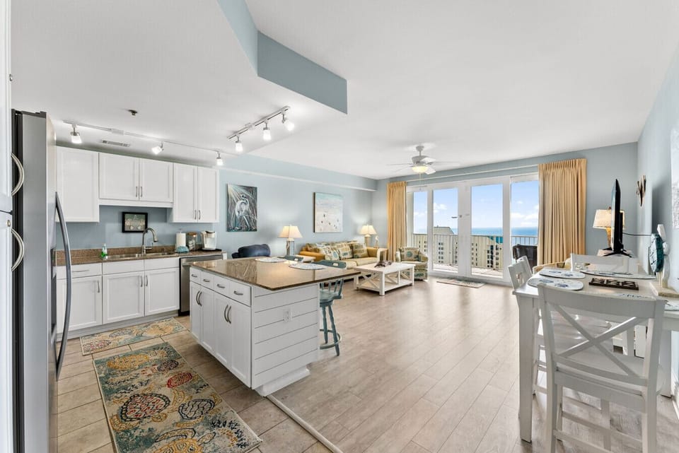 pen-concept kitchen and living area with bright coastal décor and stunning floor-to-ceiling Gulf views.
