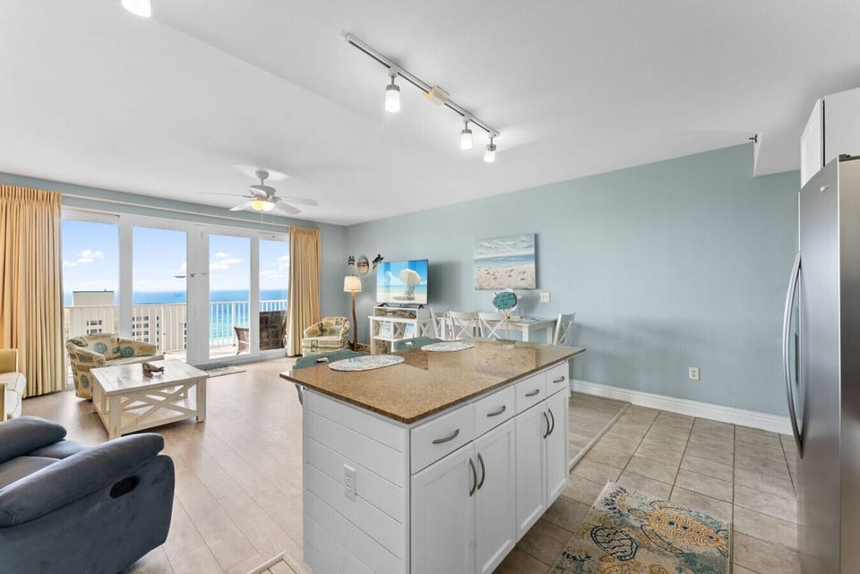 Spacious living room with large windows showcasing panoramic Gulf views, perfect for relaxing in a breezy beach atmosphere.