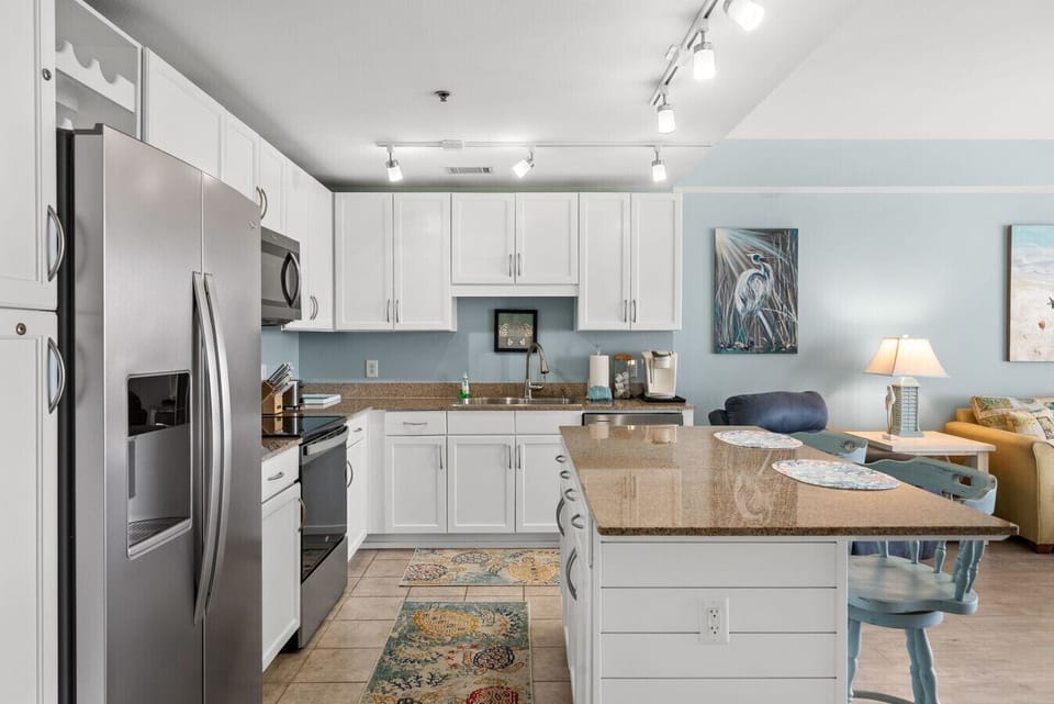 Bright, open kitchen with ample counter space, modern appliances, and bar seating for easy vacation meals.