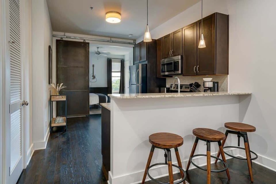 Unit 1: Fully equipped kitchen with stainless steel appliances and bar seating.